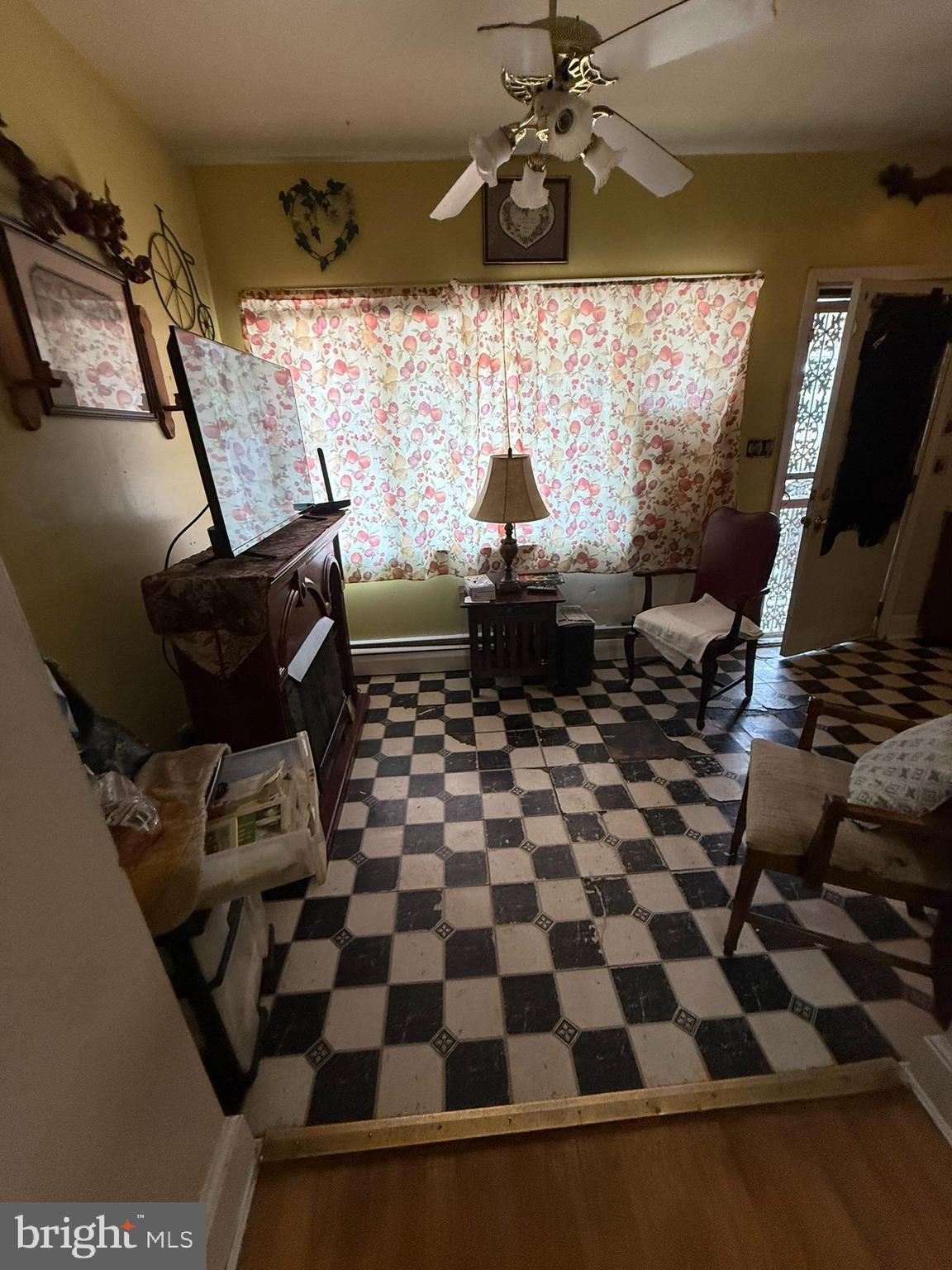 2812 6th Street Northeast Washington, DC 20017 - Photo 4 of 11 a living room with a black white checkered floor with a gaming machine and dining chairs