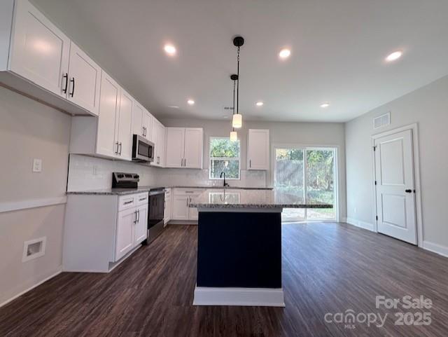212 Queens Court Gastonia, NC 28052 - Photo 11 of 42 a kitchen with kitchen island granite countertop a stove a sink a refrigerator cabinets and wooden floor