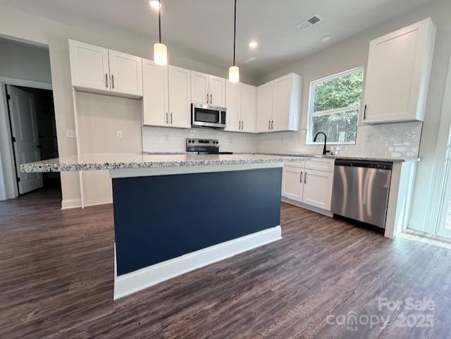 212 Queens Court Gastonia, NC 28052 - Photo 12 of 42 a kitchen with stainless steel appliances granite countertop a white cabinets a sink a stove a refrigerator and island with wooden floor