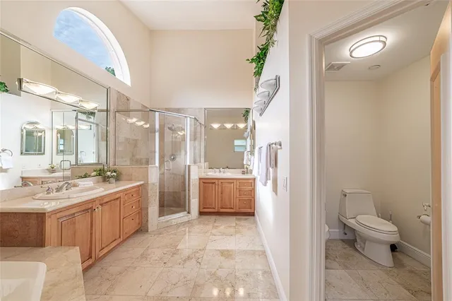 a bathroom with a double vanity sink toilet and shower