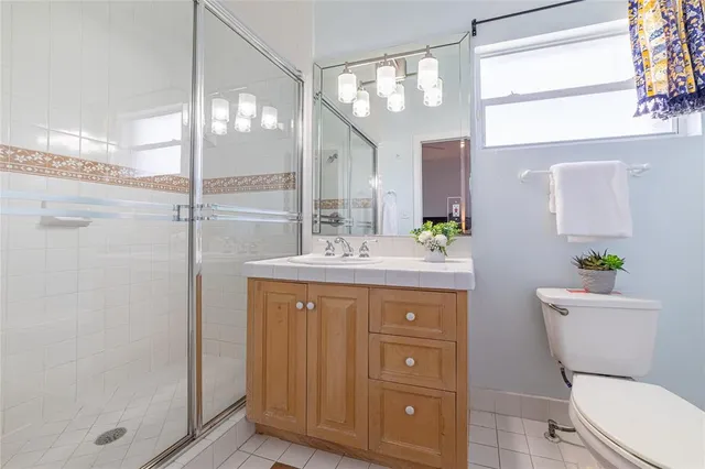 a bathroom with a granite countertop toilet a sink and a mirror