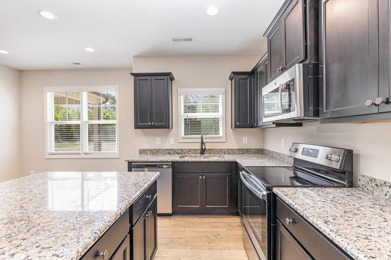 426 Jackson Pond Drive Smithfield, NC 27577 - Photo 13 of 32 a kitchen with stainless steel appliances granite countertop a sink stove and cabinets