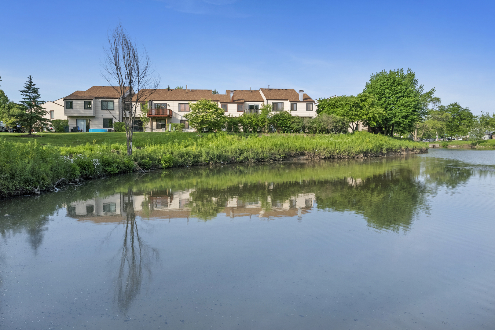 375 Juniper Tree Court Hoffman Estates, IL 60169 - Photo 22 of 24 a view of a lake with a building in front of it