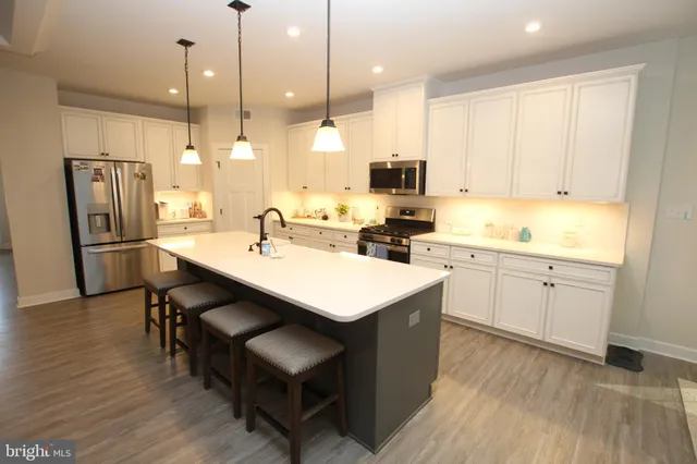 a kitchen with a sink a counter space appliances and cabinets