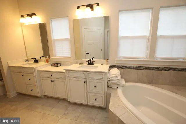 a bathroom with a tub sink and mirror