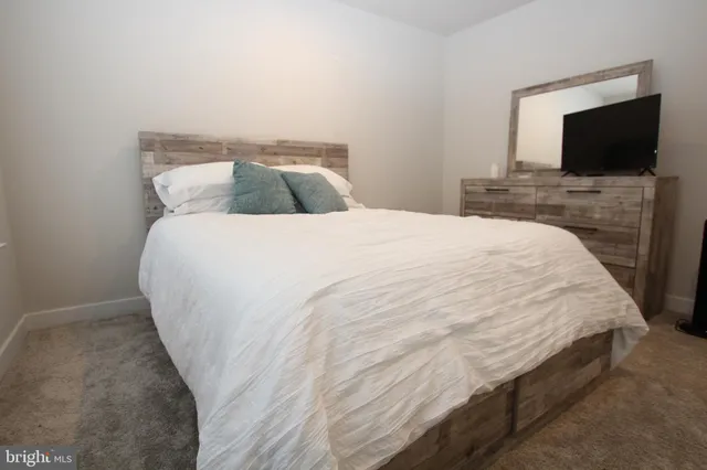 a bedroom with a bed and flat screen tv