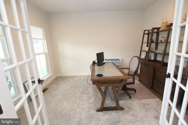 a view of a workspace with furniture and a window