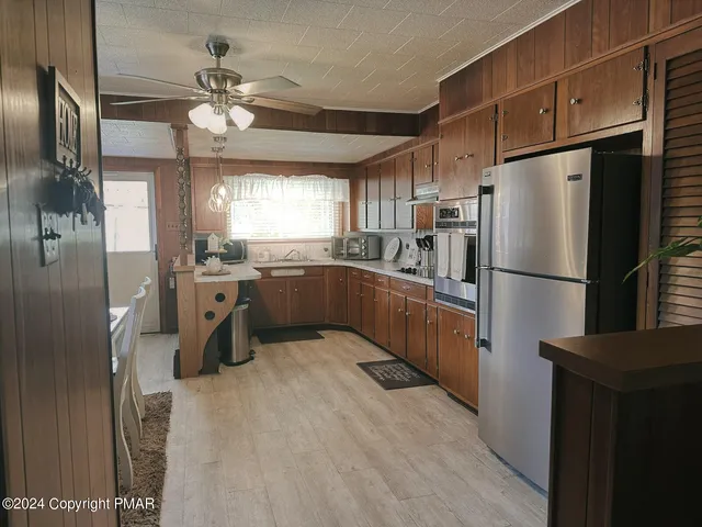 a kitchen with stainless steel appliances granite countertop a refrigerator a sink dishwasher a stove and a refrigerator