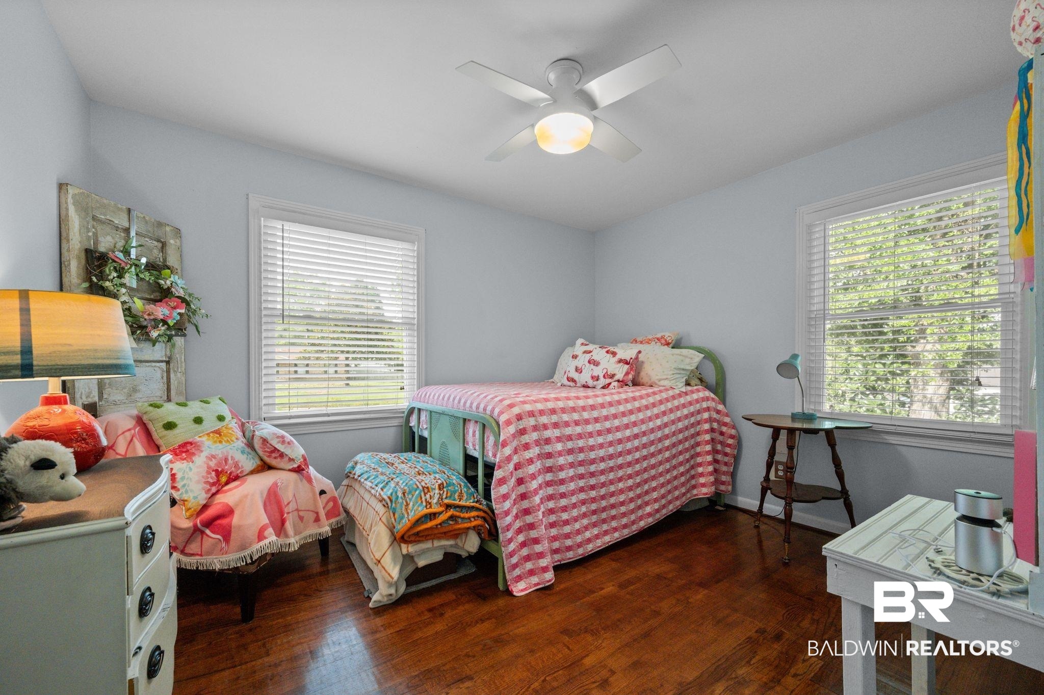 5417 Windmill Drive Mobile, AL 36693 - Photo 17 of 26 Bedroom featuring rich wood-finish flooring, light blue wall paint, and two windows with white blinds