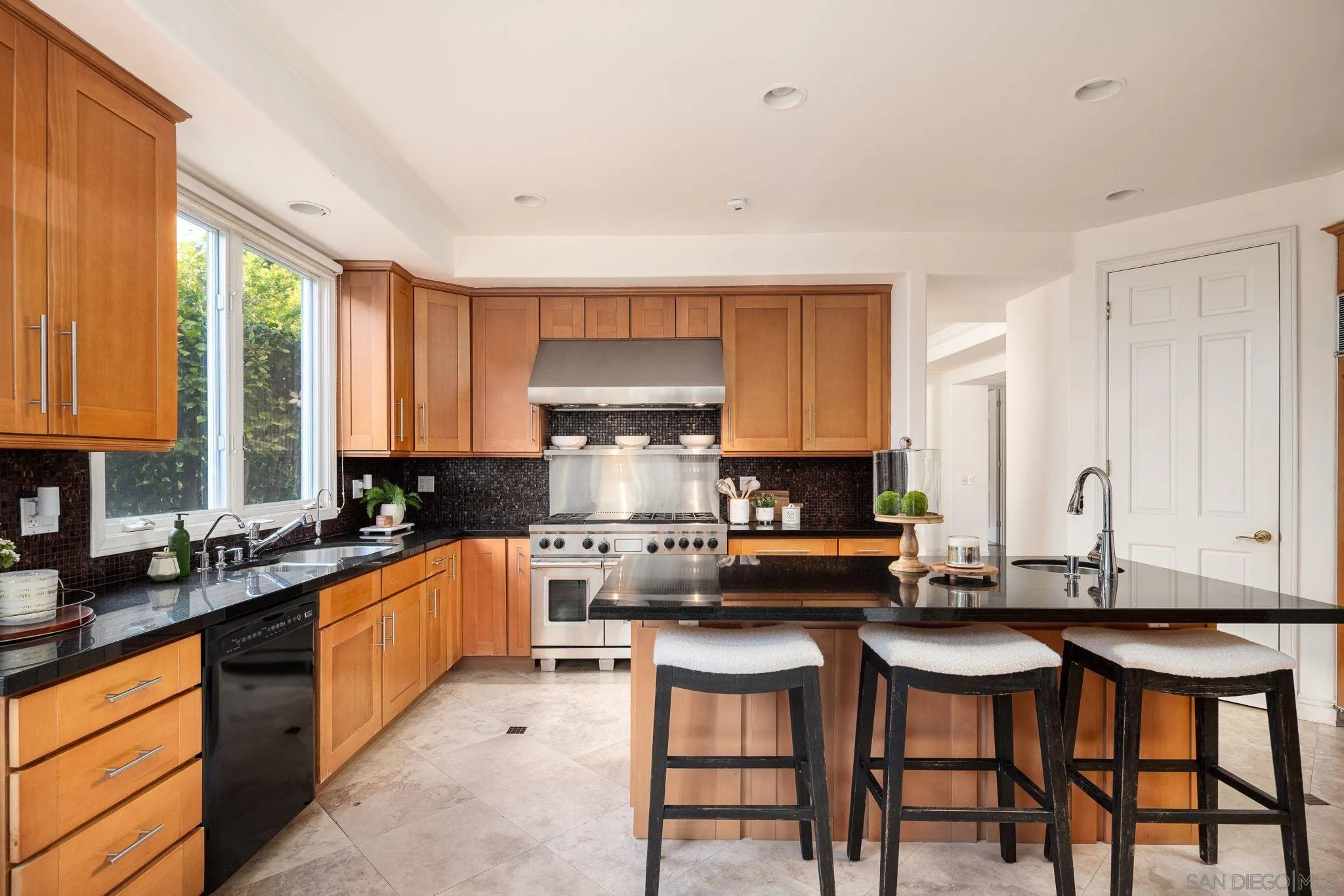 17249 Camino De Montecillo Rancho Santa Fe, CA 92067 - Photo 8 of 21 a kitchen with stainless steel appliances kitchen island granite countertop a stove a sink and white cabinets