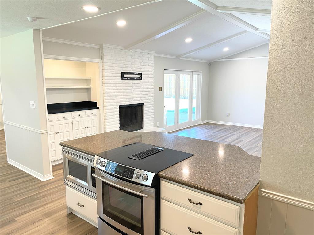 4847 Twin Post Road Dallas, TX 75244 - Photo 4 of 36 Kitchen with ornamental molding, light wood-type flooring, white cabinetry, and appliances with stainless steel finishes