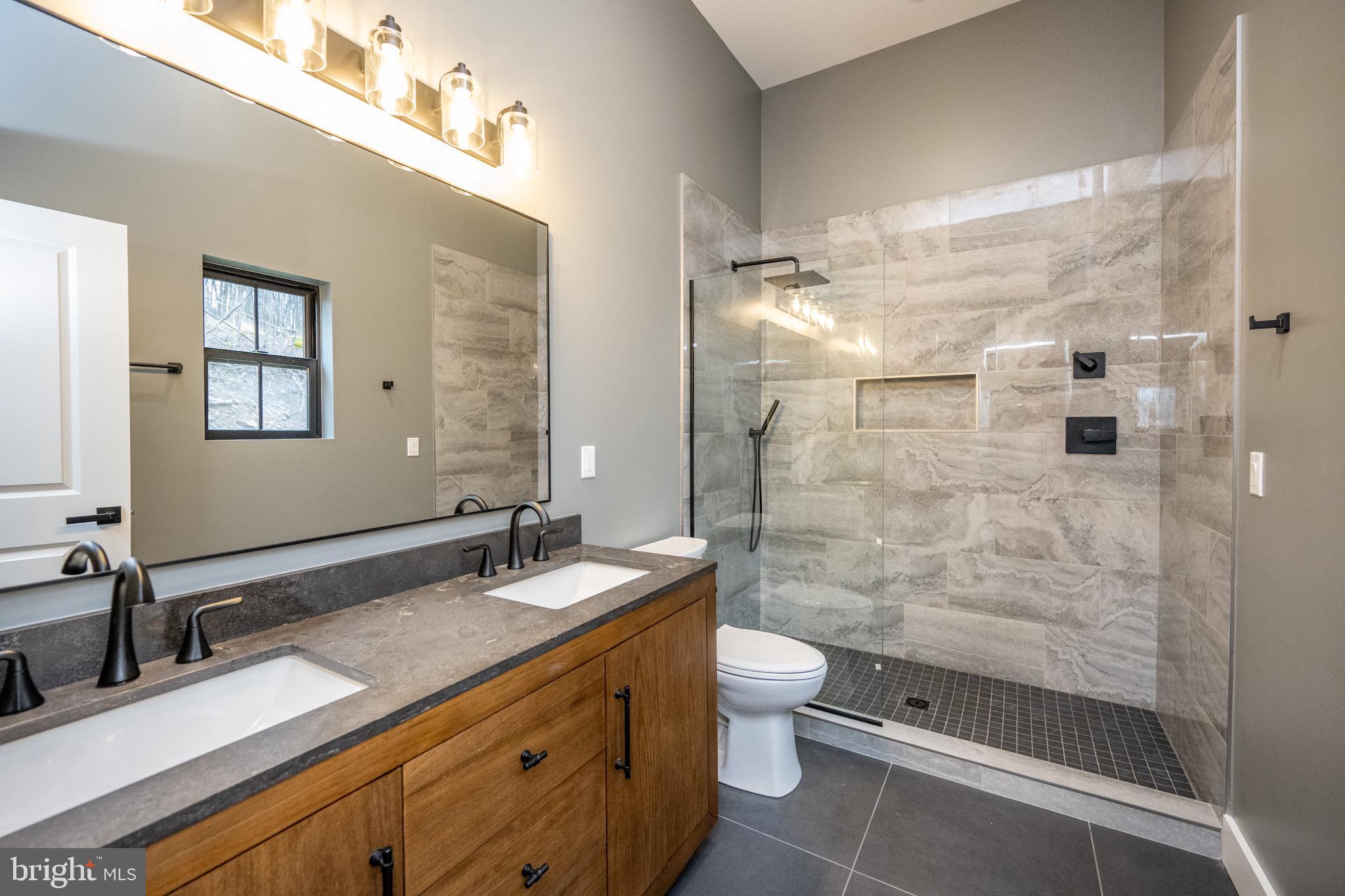 353 Lower Camp Road McHenry, MD 21541 - Photo 19 of 67 a bathroom with a double vanity sink toilet and shower