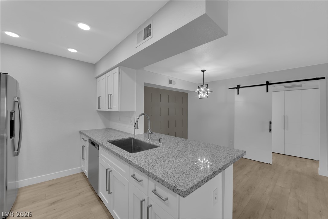 8101 West Flamingo Road, Unit 2152 Las Vegas, NV 89147 - Photo 7 of 45 A streamlined kitchen island with granite counters complements the sleek stainless steel appliances.