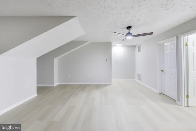 a view of an empty room with a ceiling fan