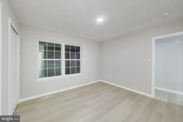 a front view of a house with large trees