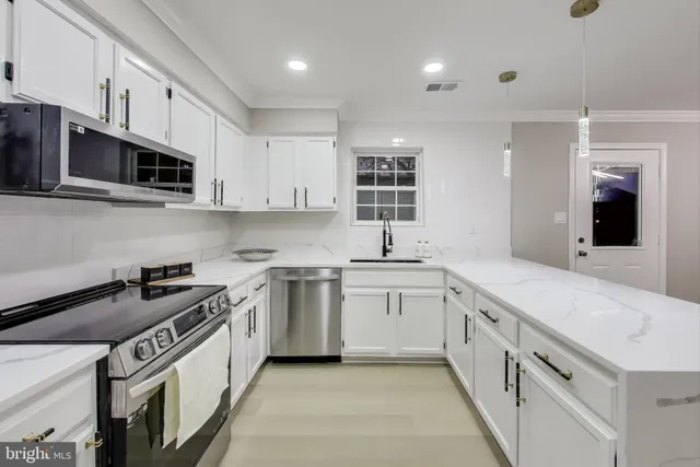 a kitchen with stainless steel appliances granite countertop a sink and a stove