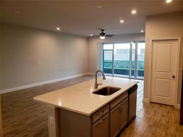 a kitchen with a sink a counter space and wooden floor