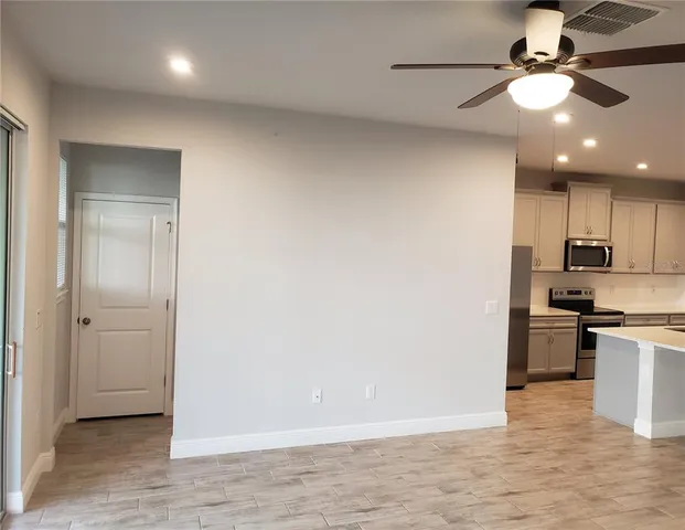 a view of kitchen with stainless steel appliances granite countertop cabinets and wooden floor