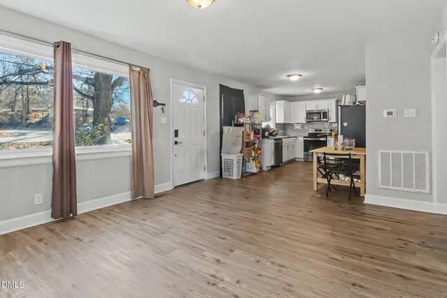 an empty room with wooden floor and windows