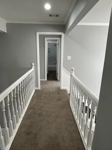 a view of a hallway with wooden floor and stairs