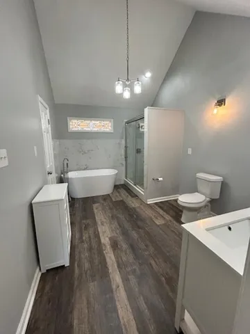 a bathroom with a sink a toilet and shower