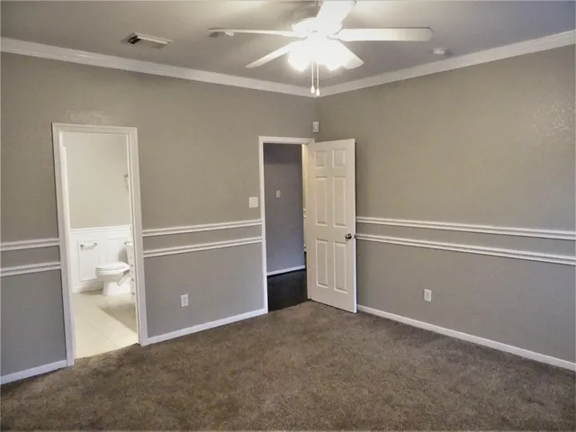 an empty room with closet and a chandelier fan