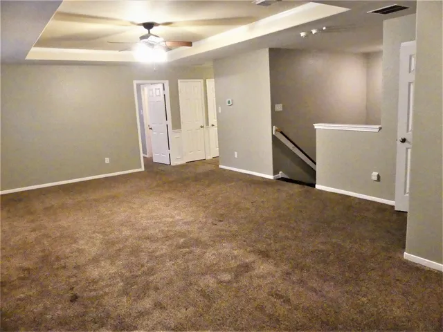 an empty room with closet and a chandelier fan