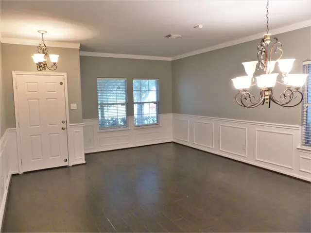 an empty room with wooden floor and cabinet