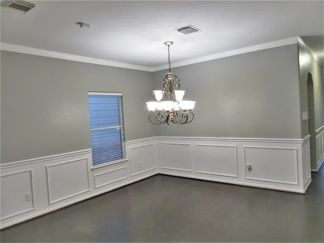 a view of an empty room with chandelier