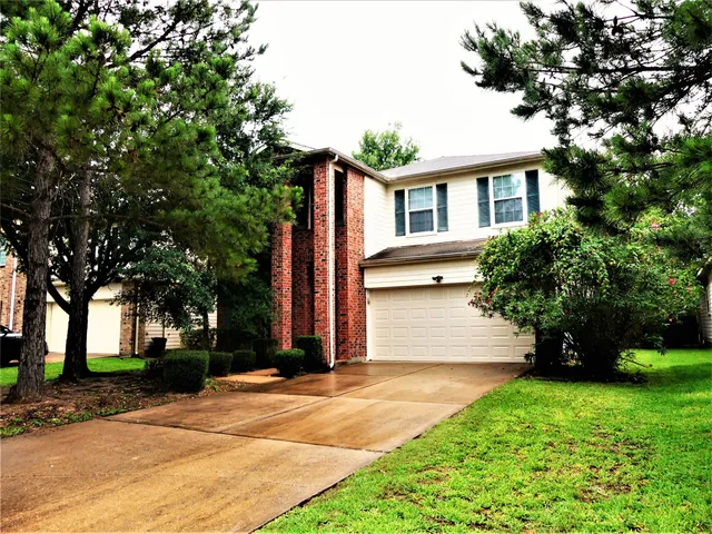 a front view of a house with a garden and tree
