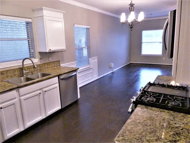 a kitchen with stainless steel appliances granite countertop a sink stove and cabinets
