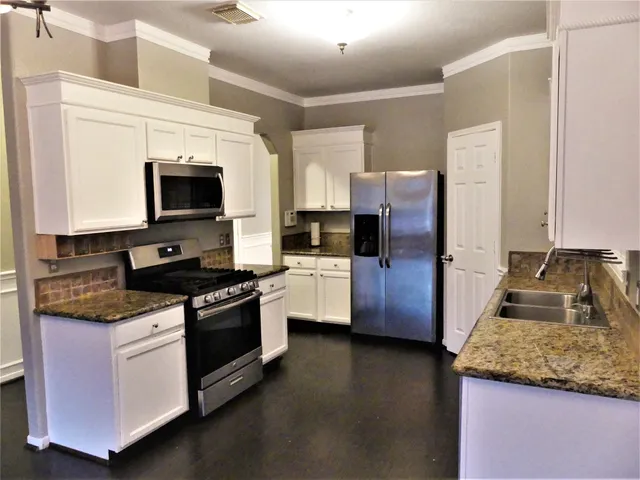 a kitchen with granite countertop stainless steel appliances and wooden cabinets