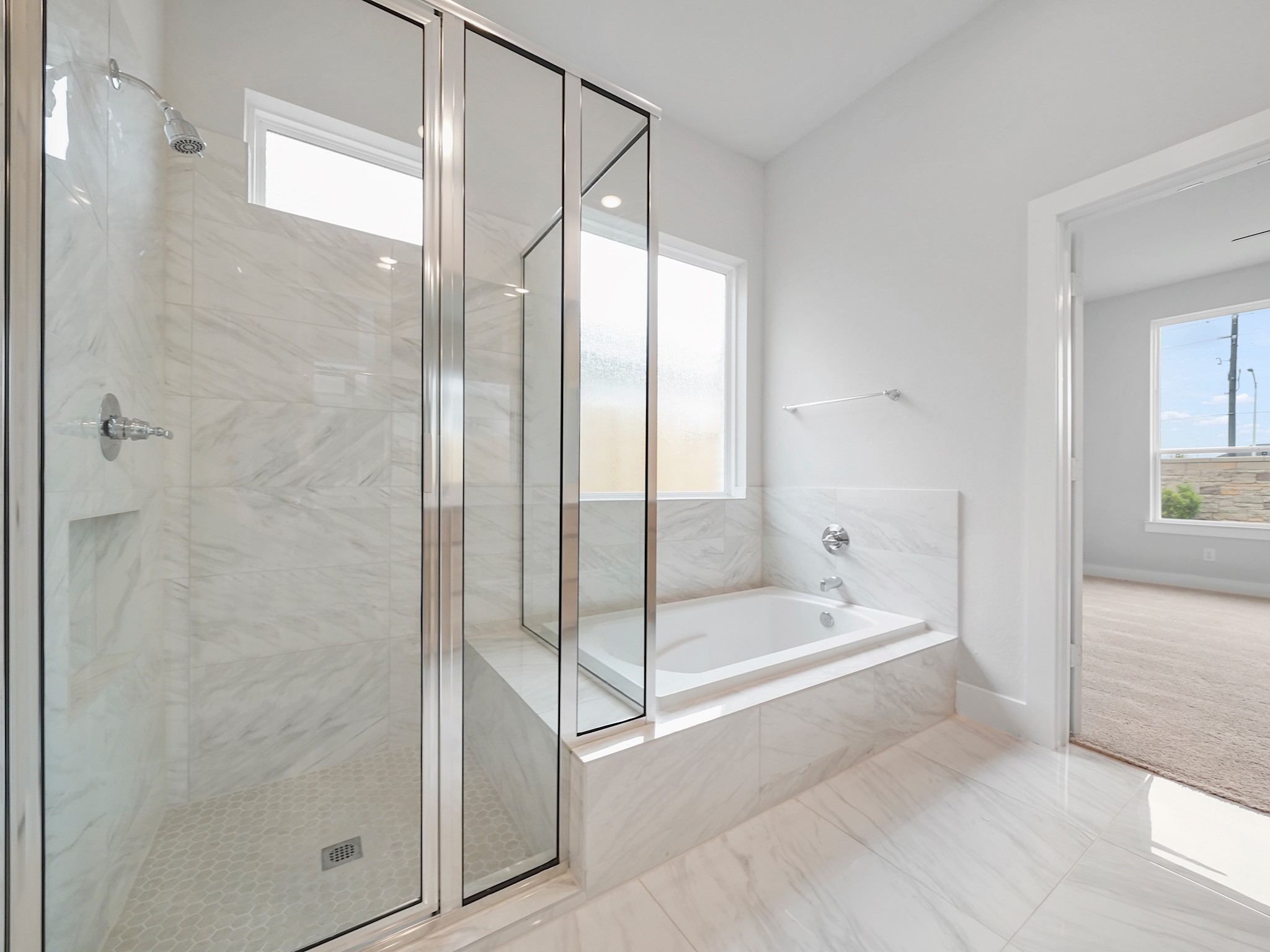 6010 Rolling Strm Court Fulshear, TX 77441 - Photo 11 of 23 Enjoy the convenience of both a separate shower and a soaking tub in this well-appointed bathroom. The strategically placed glazed window above the tub allows for ample natural light while maintaining privacy.