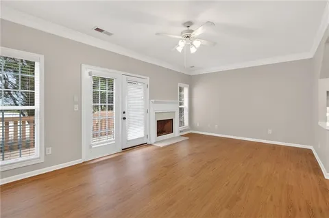 a view of an empty room with chandelier fan and fire place