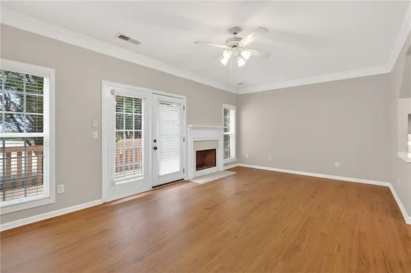 a view of an empty room with chandelier fan and fire place