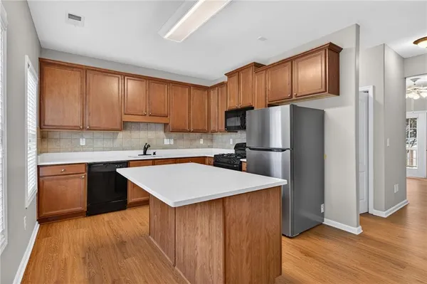 a kitchen with wooden cabinets a refrigerator and a sink
