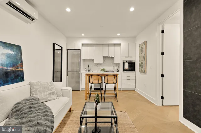 a living room with stainless steel appliances kitchen island granite countertop furniture and a refrigerator