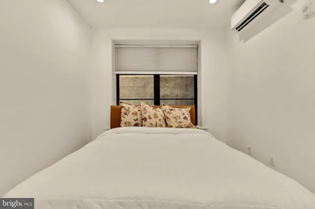 a large bed sitting in a bedroom next to a window