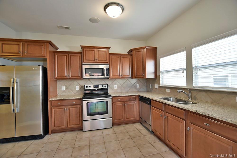 2328 Celandine Way Tega Cay, SC 29708 - Photo 4 of 15 a kitchen with stainless steel appliances granite countertop a sink a stove a refrigerator cabinets and a window