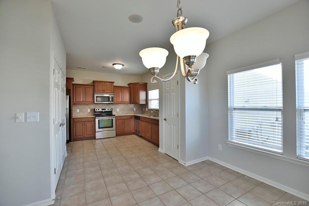 2328 Celandine Way Tega Cay, SC 29708 - Photo 6 of 15 a kitchen with stainless steel appliances granite countertop a stove a refrigerator a sink a microwave oven with white cabinets