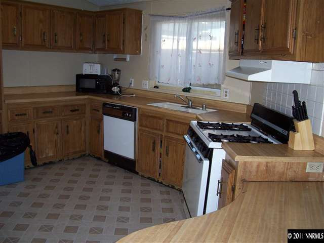 2688 Zinnia Avenue Reno, NV 89512 - Photo 2 of 6 a kitchen with a sink stove top oven and cabinets