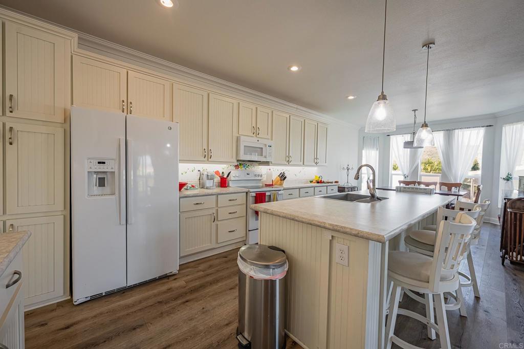 4650 Dulin Road, Unit 137 Fallbrook, CA 92003 - Photo 12 of 54 a kitchen with a sink a refrigerator and white cabinets