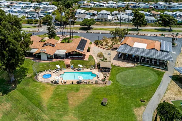 an aerial view of a house with swimming pool tennis courts and ocean view