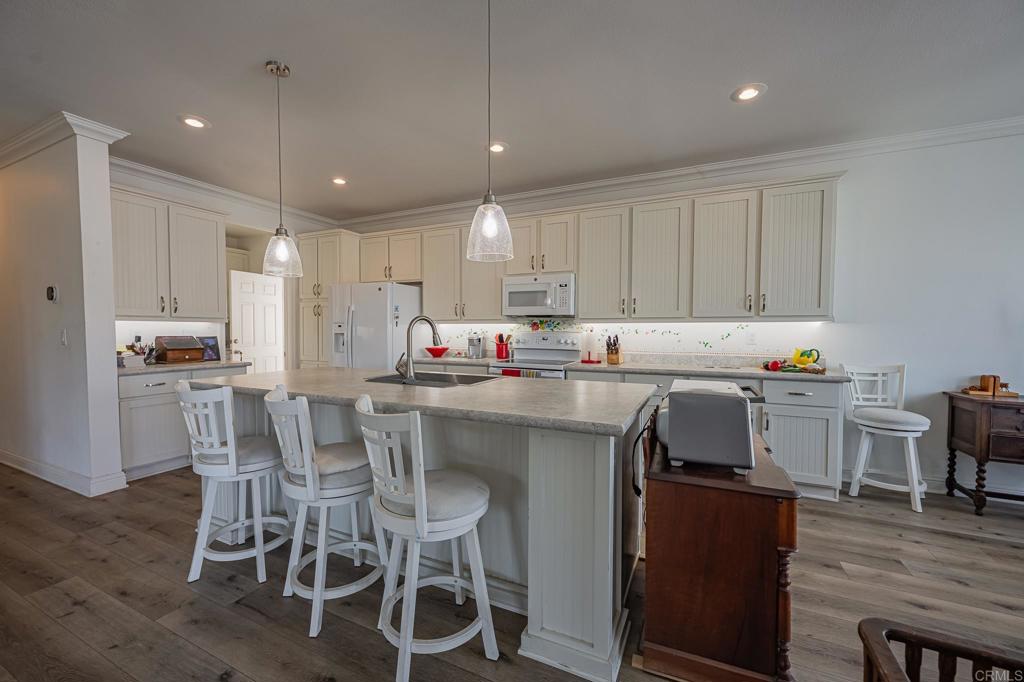 4650 Dulin Road, Unit 137 Fallbrook, CA 92003 - Photo 7 of 54 a kitchen with stainless steel appliances granite countertop a table chairs sink refrigerator and cabinets