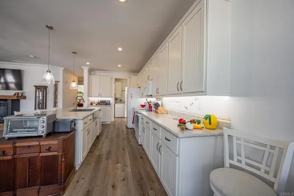 a kitchen that has a lot of cabinets in it and wooden floors