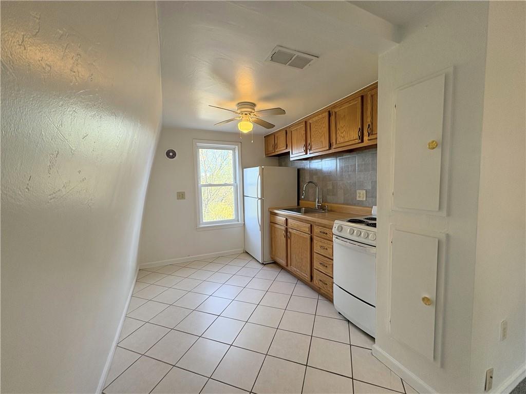 467 Oneida Street, Unit 2 Pittsburgh, PA 15211 - Photo 5 of 6 a kitchen with granite countertop a refrigerator and a stove top oven
