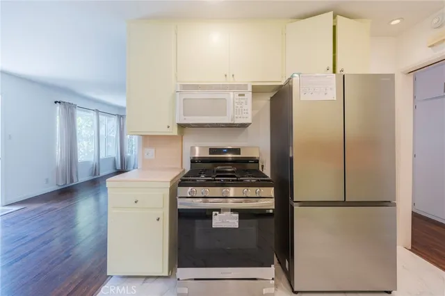 a kitchen with stainless steel appliances granite countertop a stove a refrigerator and a cabinets