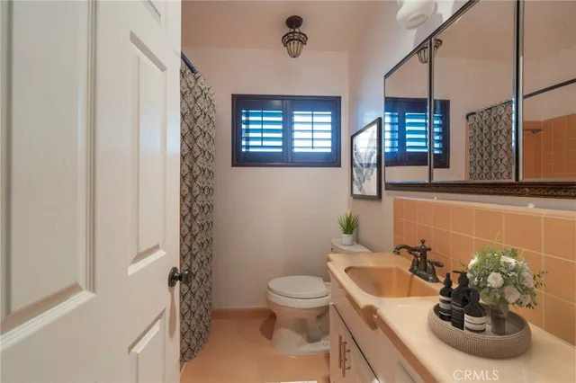 a bathroom with a sink a toilet and mirror