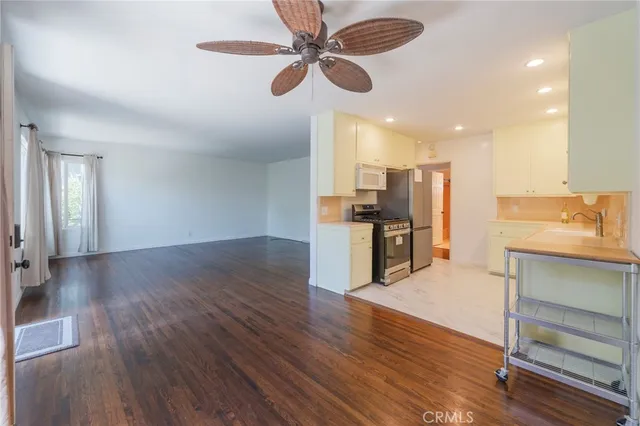 a view of kitchen with cabinets appliances and wooden floor