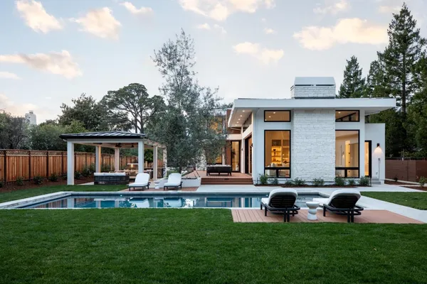 a view of a patio with couches chairs dining table and chairs with wooden floor